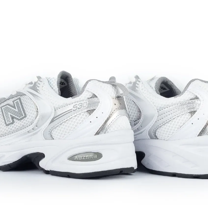 Tênis New Balance 530 branco feminino em vista lateral para avaliação de ajuste